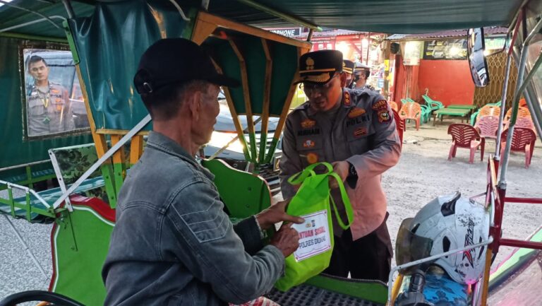 Kapolres Dumai AKBP Nurhadi Ismanto menyerahkan paket sembako pada tukang becak. F : HMSPOL